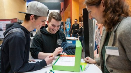 Maja Riedel erläutert einem Schüler den Parcours, den ein Roboter abfahren soll.