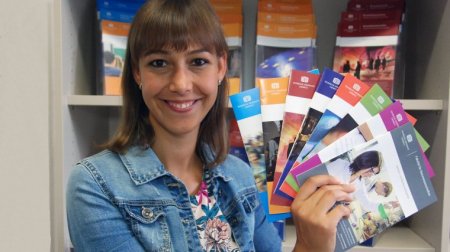 Juliane Wenzel von der Zentralen Studienberatung zeigt eine Auswahl von Studiengangsflyern.