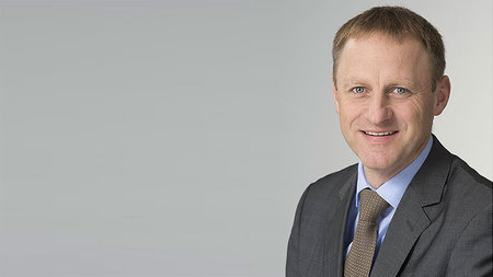 Mann mittleren Alters lächelt.