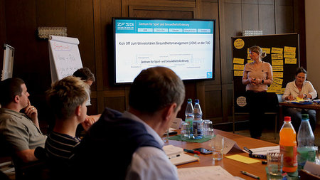 Attendees of the university health management kick-off event in conversation. 