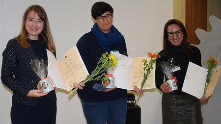 Drei Frauen halten Urkunden in den Händen