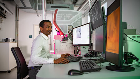 Photo of a man working at a computer in a lab.
