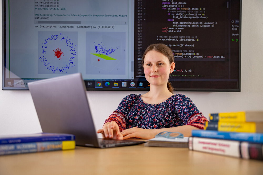 Studierende vor Laptop und Smartboard